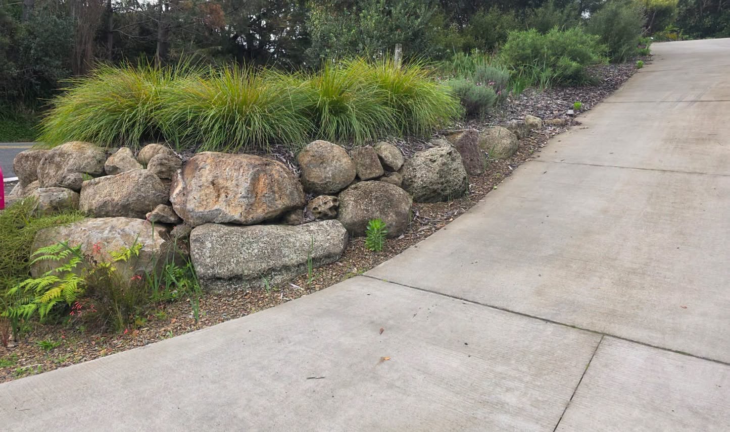 A low stone retaining edge bordering a sloped planted area.