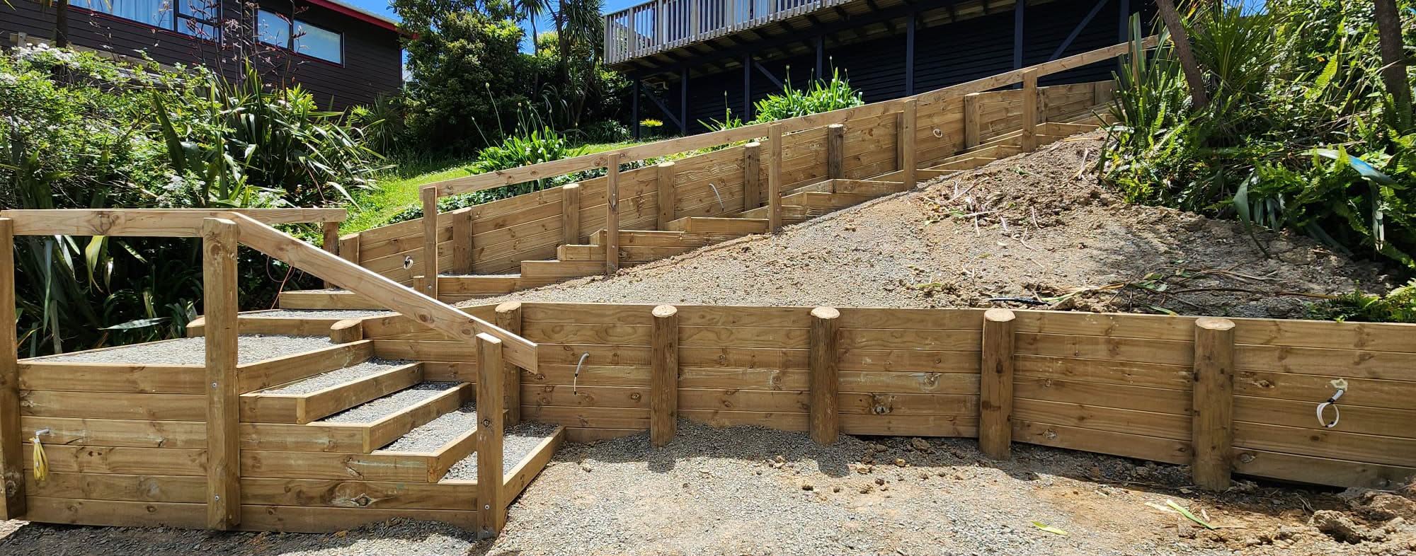 Tiered timber retaining walls across a sloping garden.